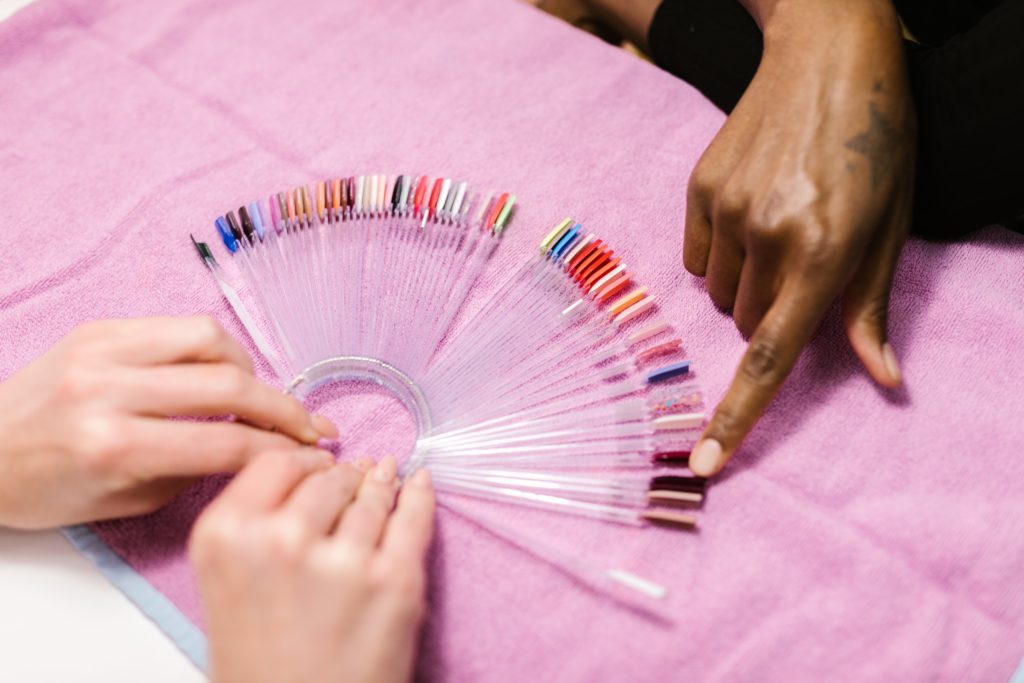 Lady pointing to acrylic nails in a salon